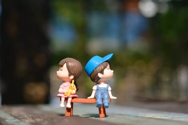 boy-and-girl-sitting-on-bench-toy